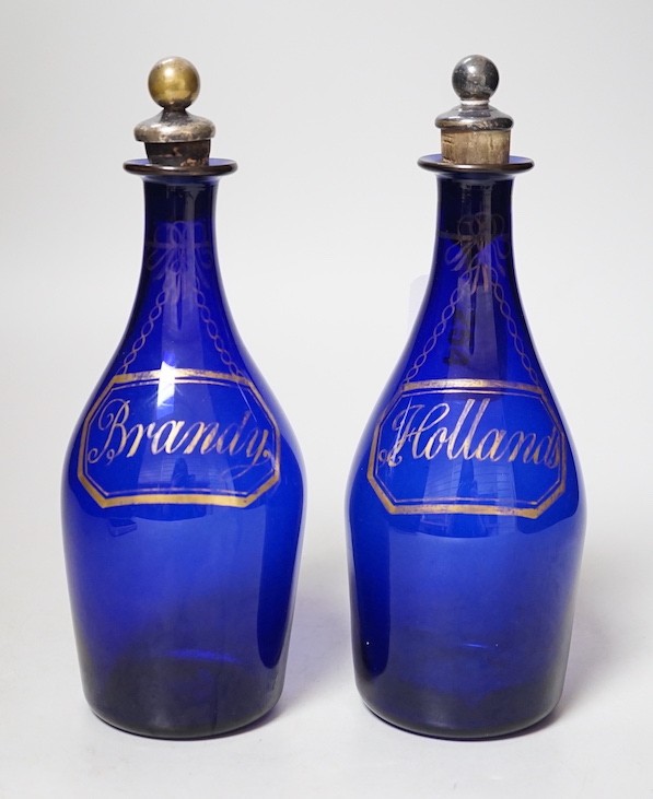 A pair of Regency blue glass decanters, labelled in gilt; Brandy and Hollands, 19cms high not including stoppers